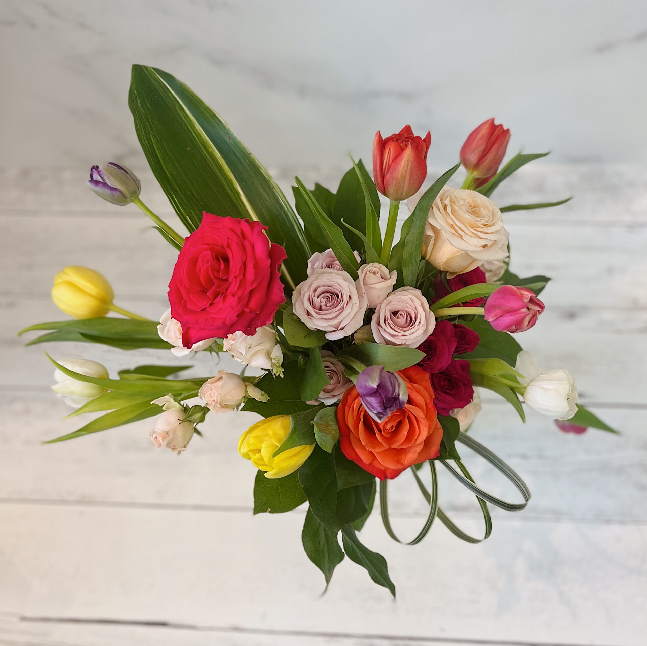 spring flower arrangement tulips, roses and spray roses
